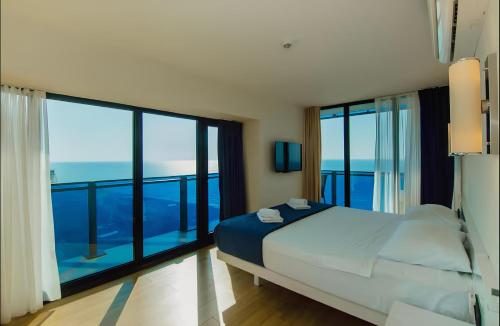 a bedroom with a bed with a view of the ocean at Batumi black sea view central Hotel in Batumi