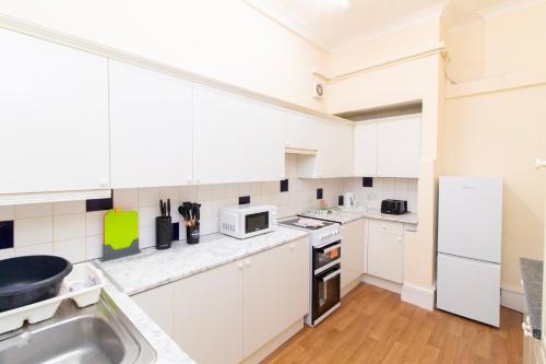 a kitchen with white cabinets and a sink at Brookvale Guest House Room 15 in Southampton
