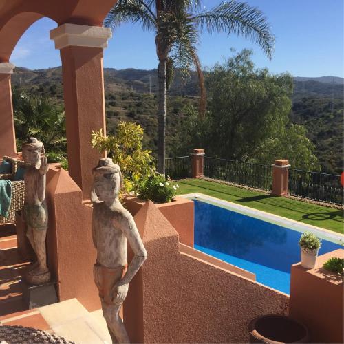 a statue in front of a house with a swimming pool at The Marbella Heights Boutique Hotel in Marbella