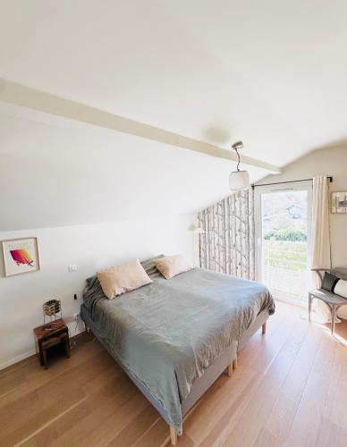 une chambre avec un lit et une grande fenêtre dans l'établissement Maison avec panorama sur les montagnes basque, à Urrugne