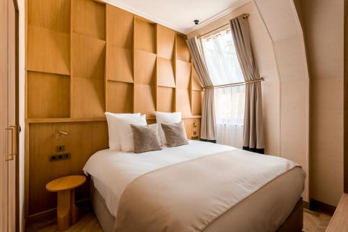 une chambre avec un grand lit blanc avec une fenêtre dans l'établissement Merveil - Signature Suite - Tour Eiffel -Desaix II, à Paris