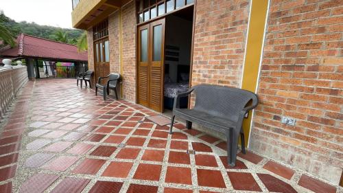 a patio with two chairs and a brick building at Casa Campestre Villateresita in Anapoima