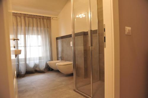 a bathroom with a toilet and a glass shower at B&B Villa Anna in Lucca