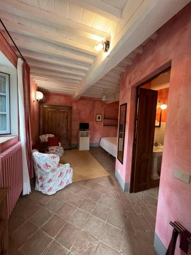 a room with pink walls and a bedroom with a bed at La Locanda Volpaia in Radda in Chianti