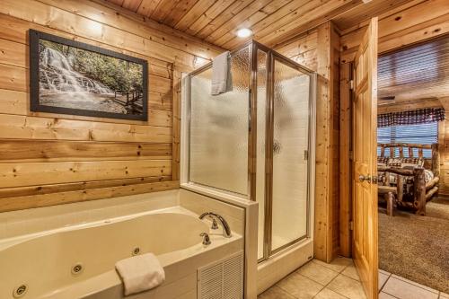 a bathroom with a tub and shower in a cabin at Hang Tenn in Sevierville