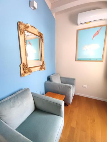a living room with two couches and a mirror at Sette Fate Suites & Spa in Palermo