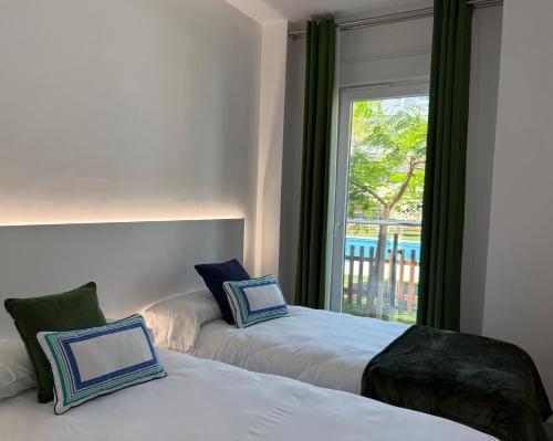 two beds in a room with a window at Apartamento Playa Granada Golf in Motril