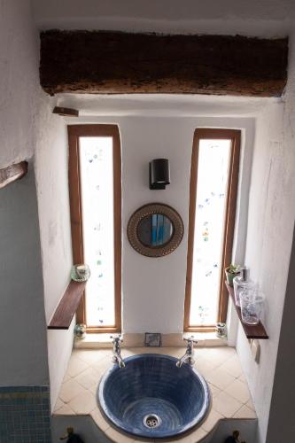 a bathroom with a blue sink and two windows at Casa del Lago in Restábal