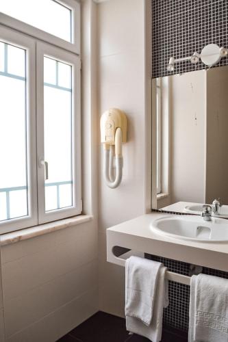 a bathroom with a sink and a mirror at Residência Maciel in Peniche