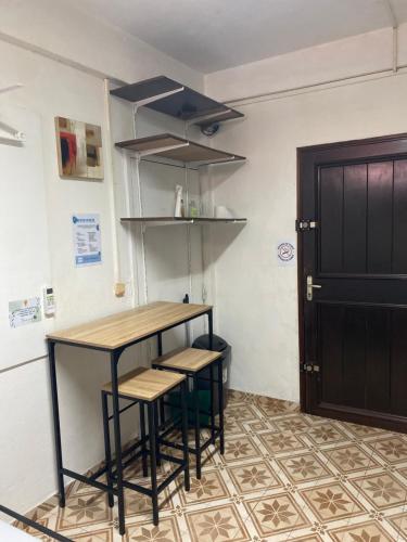 a kitchen with a table and stools next to a door at Petit coin posé in Saint-Laurent du Maroni