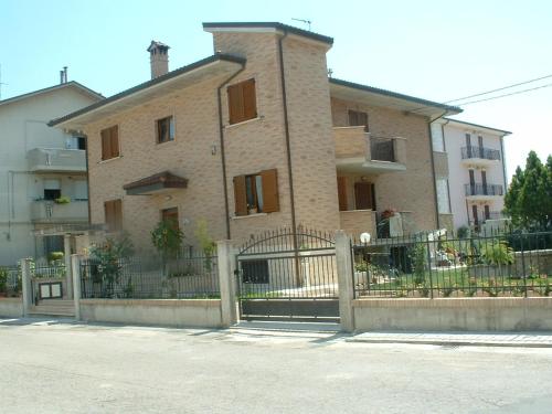 a large brick building with a fence in front of it at AFFITTACAMERE La Tartaruga in Civitanova Marche