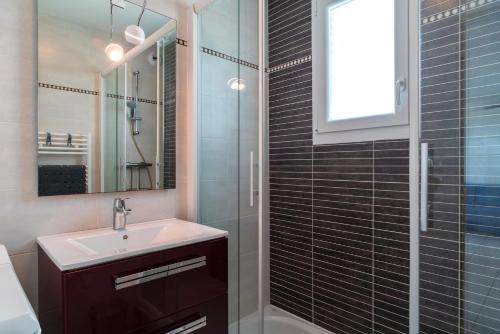 une salle de bain avec un lavabo et une douche dans l'établissement Le 47°N Crouesty - appt proche de la plage, à Arzon