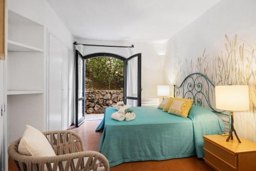 ポルト・チェルボにあるMediterranean Jewel - Panoramic Porto Cervo Aptのベッドルーム(緑のベッド1台、椅子付)