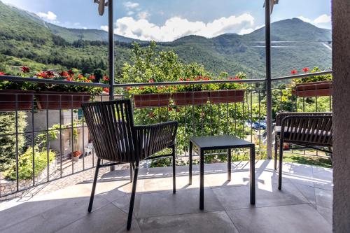 two chairs and a table on a balcony with mountains at Locanda Monte Baldo in Malcesine