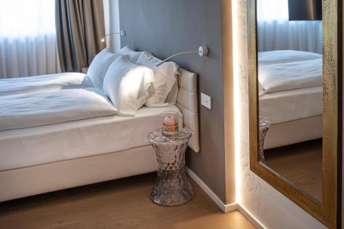 a mirror in a room with a bed and a table at Locanda Monte Baldo in Malcesine