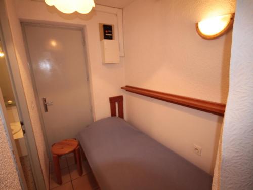 Cette petite chambre comprend un lit et une porte. dans l'établissement Studio confort 3 pers, balcon sud, Les Saisies - FR-1-293-3, aux Saisies