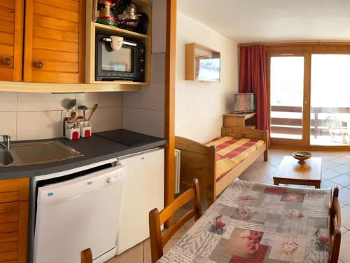 une cuisine et une salle à manger avec une table et une cuisine ainsi qu'une chambre dans l'établissement Les Saisies - Studio cabine 5 pers. avec balcon et animaux tolérés - FR-1-293-149, aux Saisies