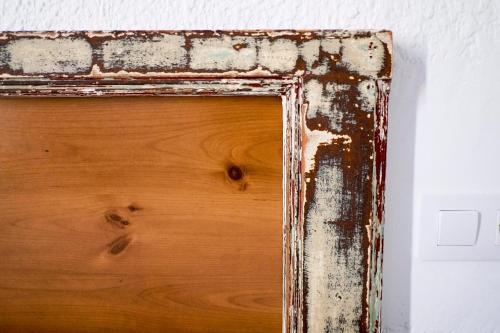 a wood frame with chipping paint on it at Pigal in Tarragona