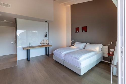a bedroom with a white bed and a table at Locanda Monte Baldo in Malcesine