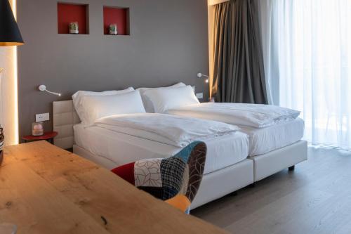 a hotel room with two beds and a table at Locanda Monte Baldo in Malcesine