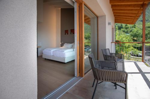 a bedroom with a bed and chairs on a balcony at Locanda Monte Baldo in Malcesine