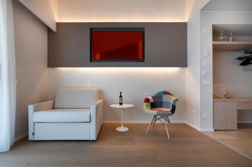 a living room with a white chair and a table at Locanda Monte Baldo in Malcesine