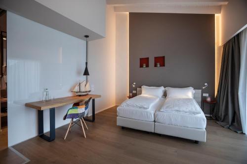 a bedroom with a white bed and a desk at Locanda Monte Baldo in Malcesine