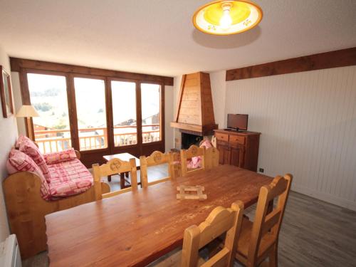 une salle à manger avec une table et des chaises en bois dans l'établissement Les Saisies: Grand 2 pièces cabine, 6 pers, cheminée, balcon sud, wifi - FR-1-293-248, à Hauteluce