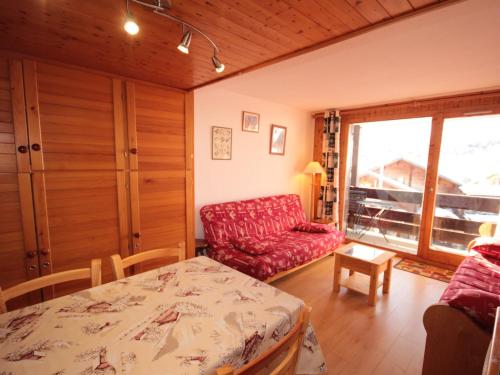 a living room with a red couch and a table at Les Saisies - Studio cabine ensoleillé pour 4 pers., animaux acceptés - FR-1-293-164 in Les Saisies