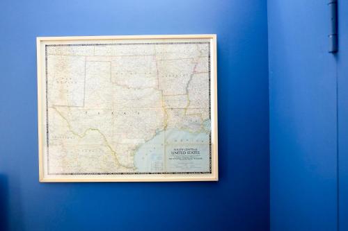 a map in a frame hanging on a blue wall at Pigal in Tarragona