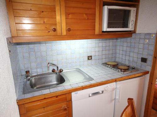 une cuisine avec un évier et un micro-ondes dans l'établissement Studio cabine avec balcon plein sud, 5 couchages, animaux tolérés, casier à skis - FR-1-293-129, aux Saisies