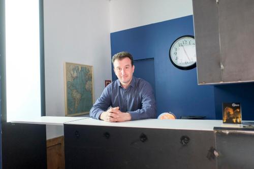 a man sitting at a counter in an office with a clock at Pigal in Tarragona