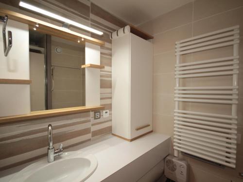 une salle de bain avec un lavabo et un miroir dans l'établissement Studio ensoleillé, équipé avec balcon au cœur des Saisies, animaux acceptés - FR-1-293-186, aux Saisies