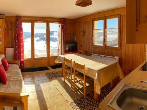 - une cuisine avec une table, des chaises et un évier dans l'établissement Appartement Les Saisies 5 pers, 35m², équipements complets - FR-1-293-329, à Hauteluce