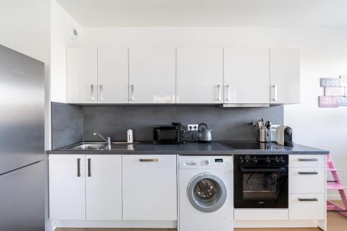a white kitchen with a sink and a dishwasher at Basel-Tram 8-Tristate-Bridge-Riverview in Huningue