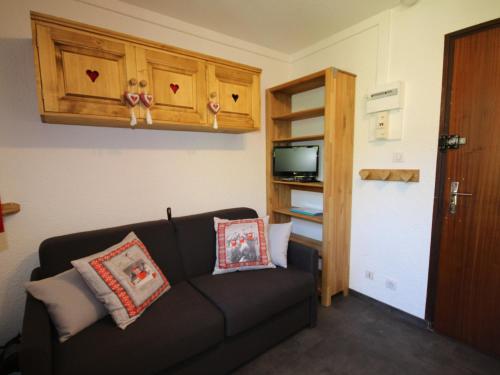 ein Wohnzimmer mit einer Couch mit Kissen darauf in der Unterkunft Studio cosy rénové - Coeur des Saisies - Proche pistes - Balcon - TV - Lave-vaisselle - 2 pers - FR-1-293-245 in Hauteluce