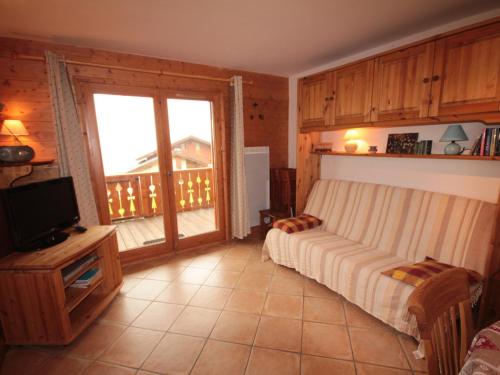 une chambre avec un lit et une télévision et un balcon dans l'établissement Magnifique T3 avec terrasse et garage à Villard-sur-Doron - FR-1-293-254, à Villard-sur-Doron