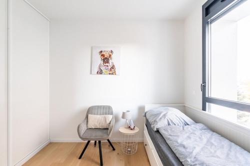 a bedroom with a bed and a chair and a window at Basel-Tram 8-Tristate-Bridge-Riverview in Huningue