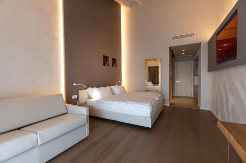 a bedroom with a white bed and a couch at Locanda Monte Baldo in Malcesine