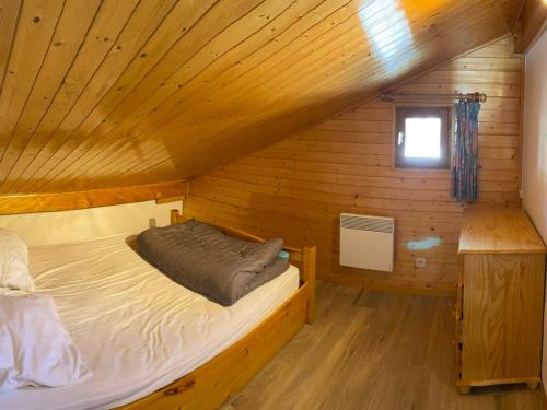 une chambre avec un lit dans une cabane en bois dans l'établissement Appartement 4 pièces, 9 pers, balcon, animaux tolérés, Les Saisies - FR-1-293-255, à Hauteluce