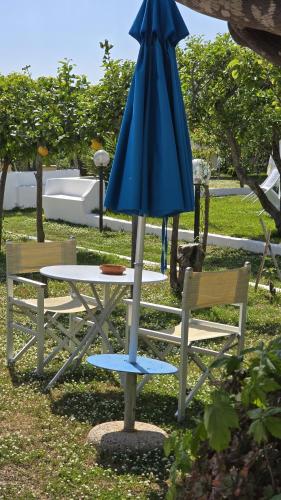a blue umbrella sitting next to a table and chairs at Hotel Savoia in Procida