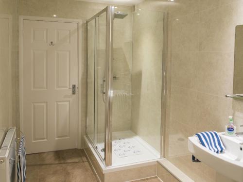 una ducha con puerta de cristal en un baño en 2 Bed in TENBY FB284, en Tenby