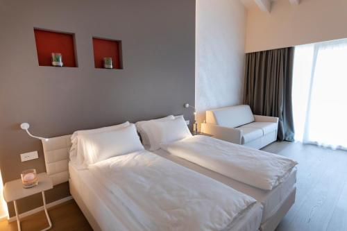 a hotel room with two beds and a chair at Locanda Monte Baldo in Malcesine