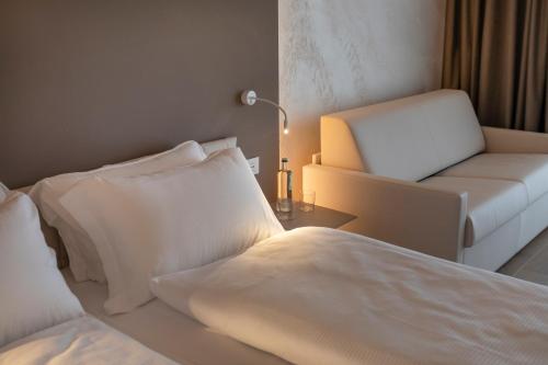 a bedroom with a bed and a couch and a chair at Locanda Monte Baldo in Malcesine