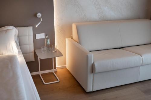 a bedroom with a white bed and a side table at Locanda Monte Baldo in Malcesine