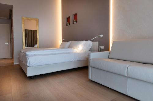 a hotel room with two beds and a couch at Locanda Monte Baldo in Malcesine