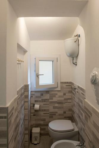 a bathroom with a toilet and a window at Casa Vacanza Gate Centro in Pisa