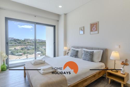 a bedroom with a bed with a large window at #312 Ocean Outlook by Home Holidays in Páteo