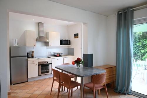 une cuisine avec une table et des chaises et une cuisine avec une fenêtre dans l'établissement La Pause Royannaise - 500 m de la plage, à Royan