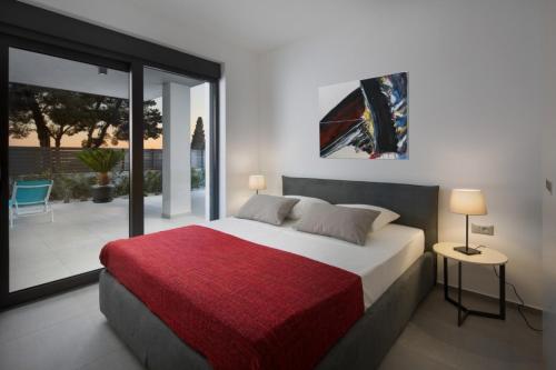 een slaapkamer met een groot bed met een rode deken bij Villa Fasana-Apartment 1 by Vivi Rent in Fažana